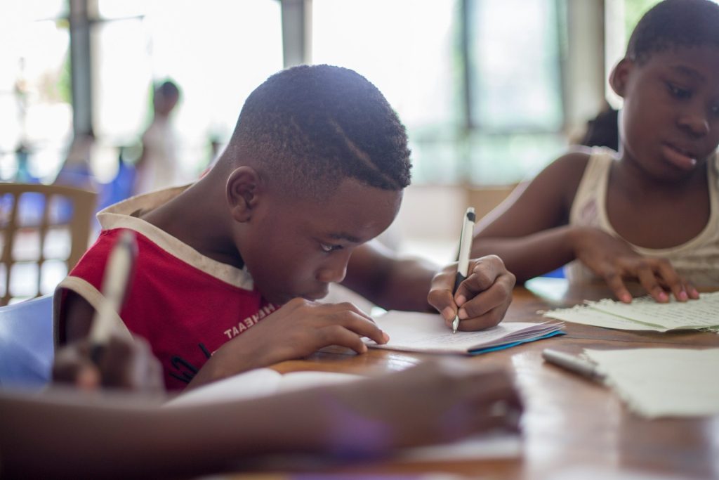 Children writing at a table