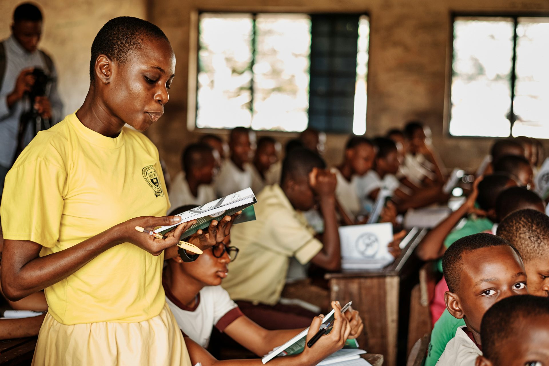 a woman standing in front of a group of children